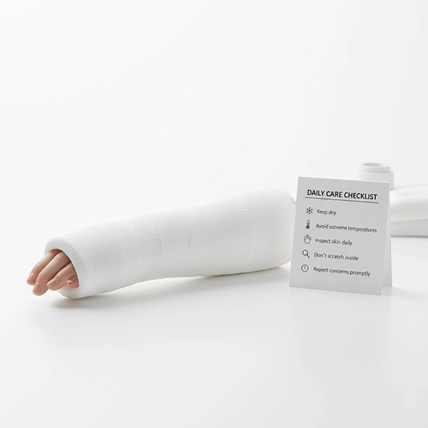 Close-up of a fiberglass cast on the forearm with a daily use-care checklist on a table