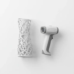 ستودیو شات از یک کست مش‌بندی سه‌بعدی پرینت‌شده کنار اسکنر دستی سه‌بعدی روی پس‌زمینه سفید