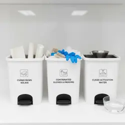 ایستگاه تفکیک پسماند رزینی کلینیک: سطل‌های برچسب‌دار برای پسماند خشکِ رزینی، دستکش و پدینگ آلوده، و بطری آب فعال‌سازی
